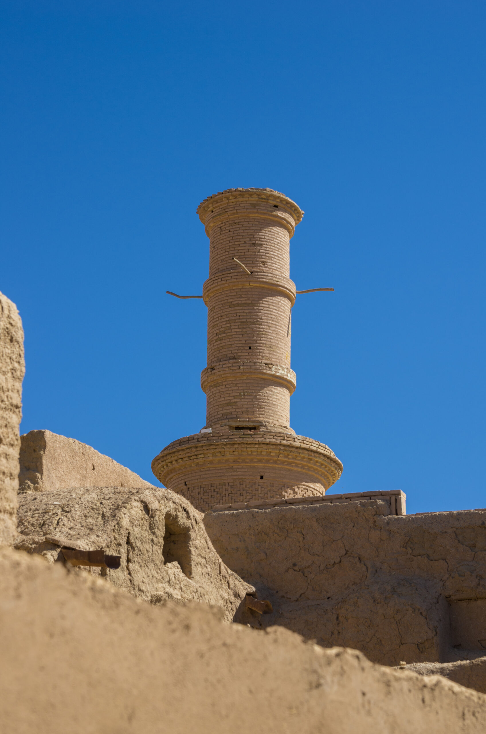Multi-storey adobe ruins and a narrow covered lane in the old town of Kharanaq.