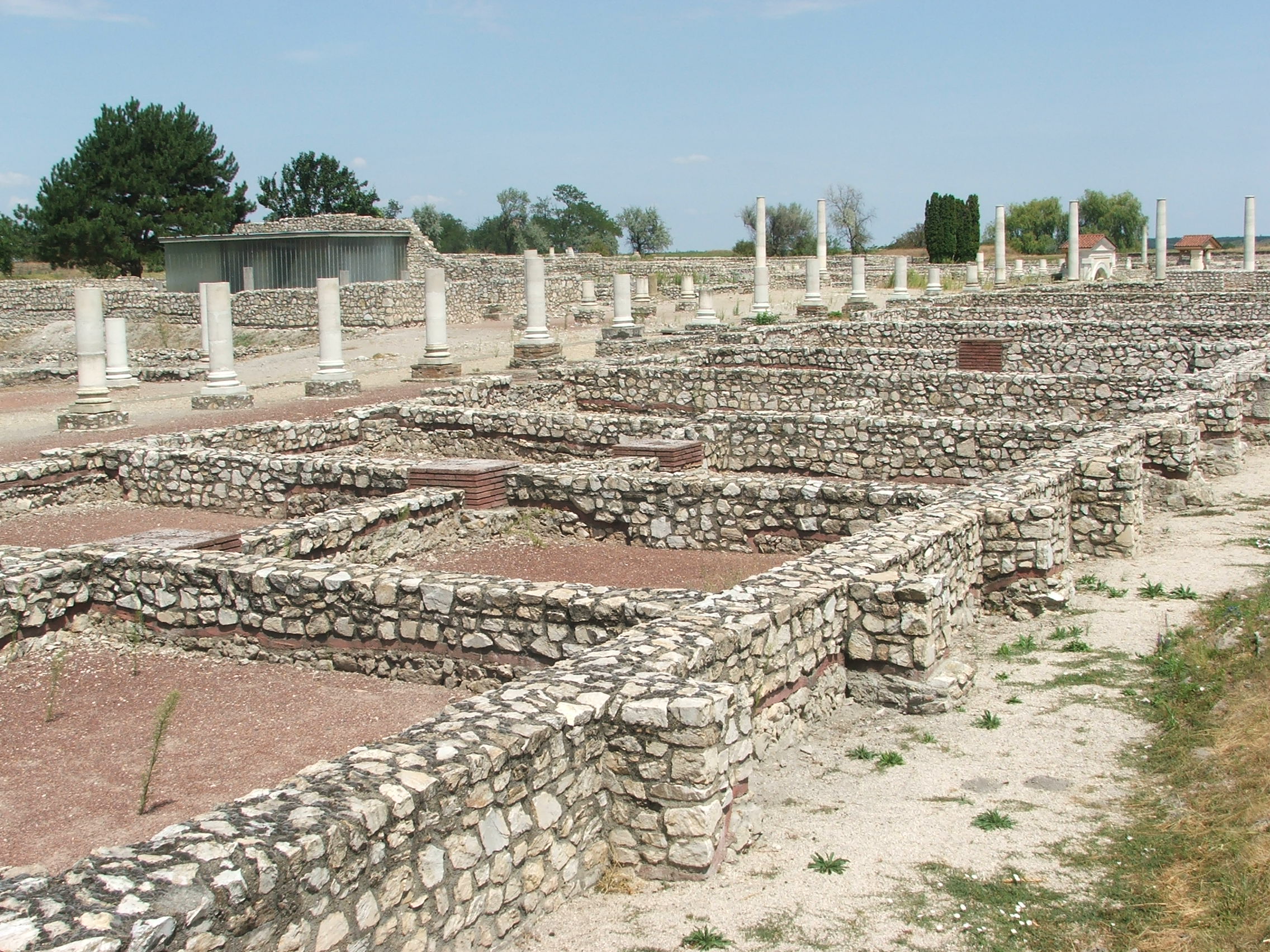 The Decumanus Maximus, the main paved street of Roman Gorsium at Tac, lined with the stone foundations of shops and houses.