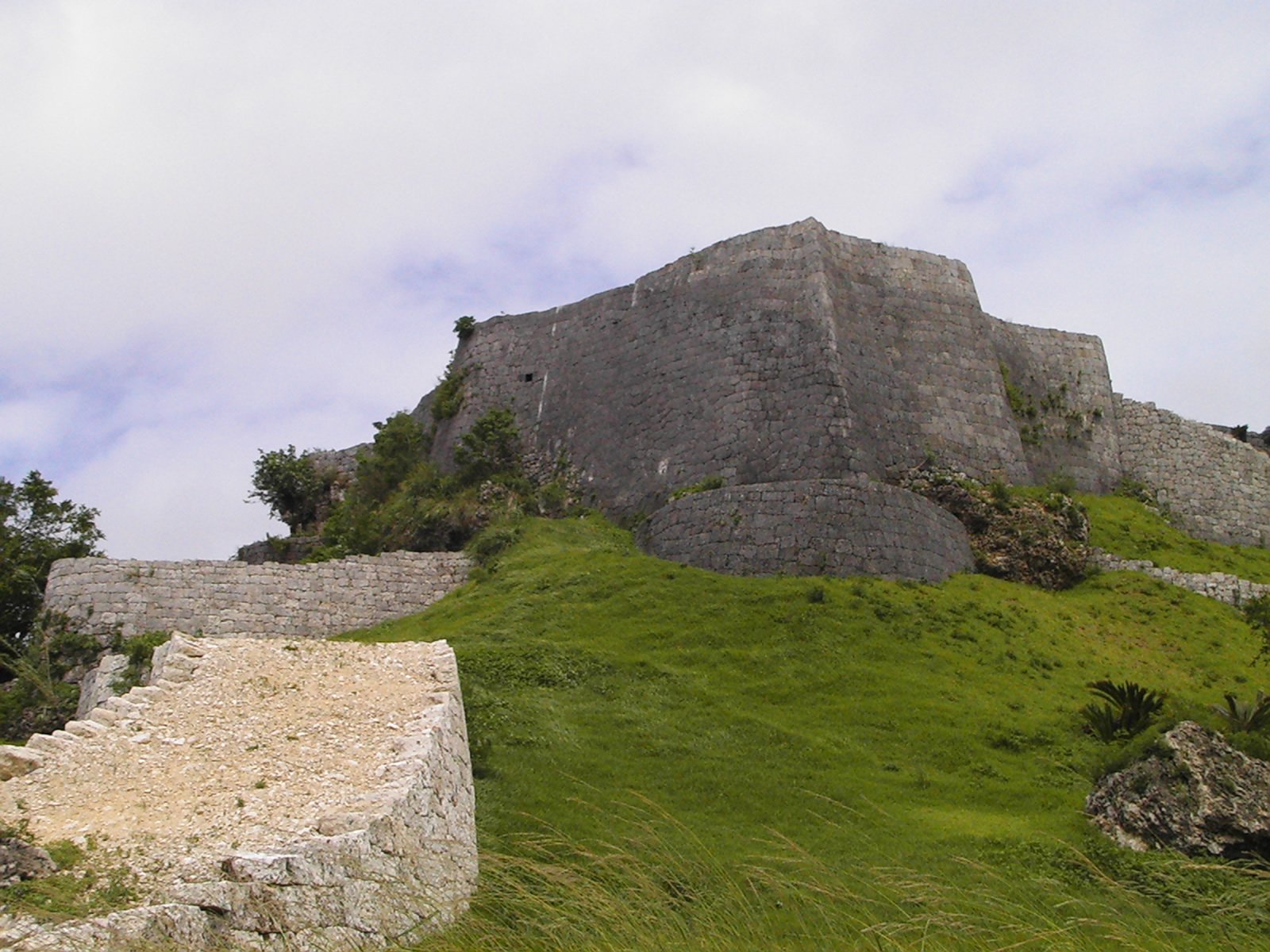 Überblick über die terrassenförmigen Steinanlagen der Burgruine Katsuren auf einem Hügel in Okinawa