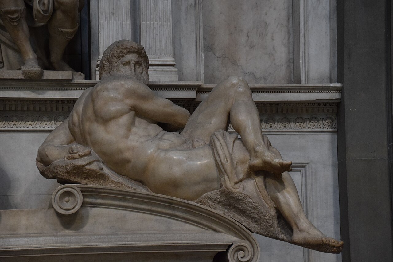 Michelangelo's marble statue Day, a muscular male nude turning his head, on the tomb of Giuliano de' Medici, carved about 1526 to 1531