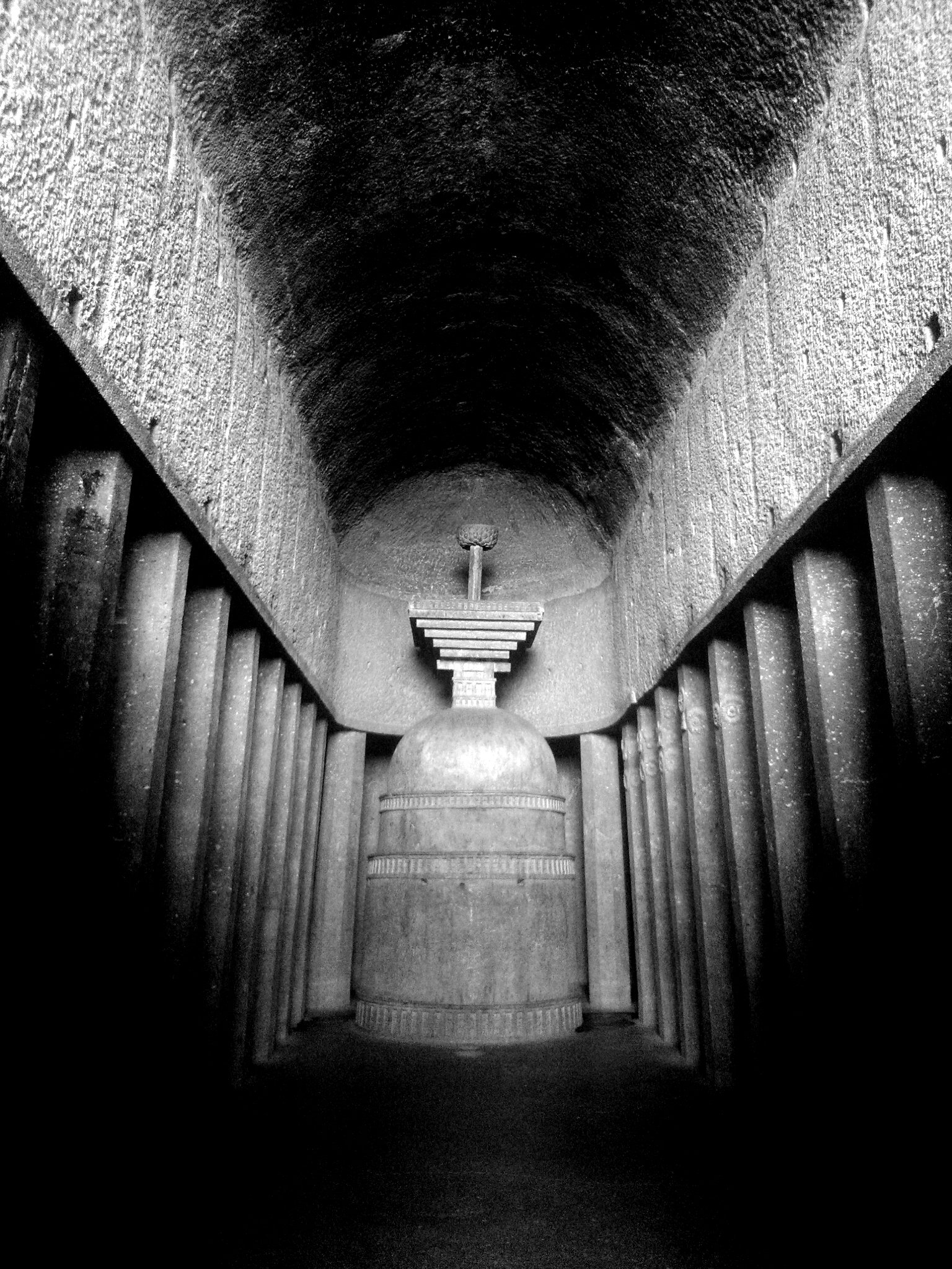 The rock-cut stupa at the apsidal end of the Bedse chaitya hall.