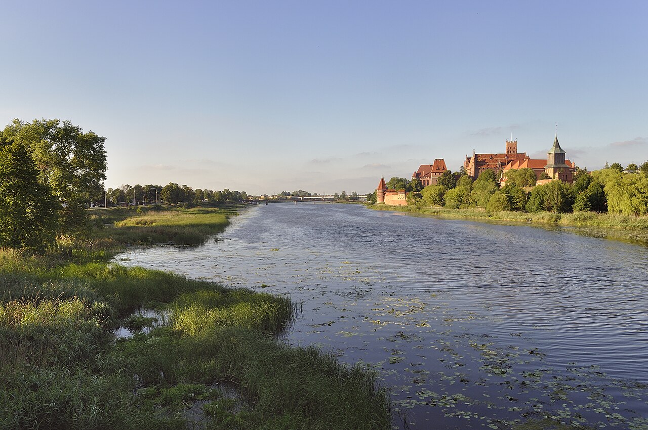 Die Marienburg, flächenmäßig die größte Burg der Welt, gesehen vom gegenüberliegenden Ufer des Flusses Nogat, Nordpolen